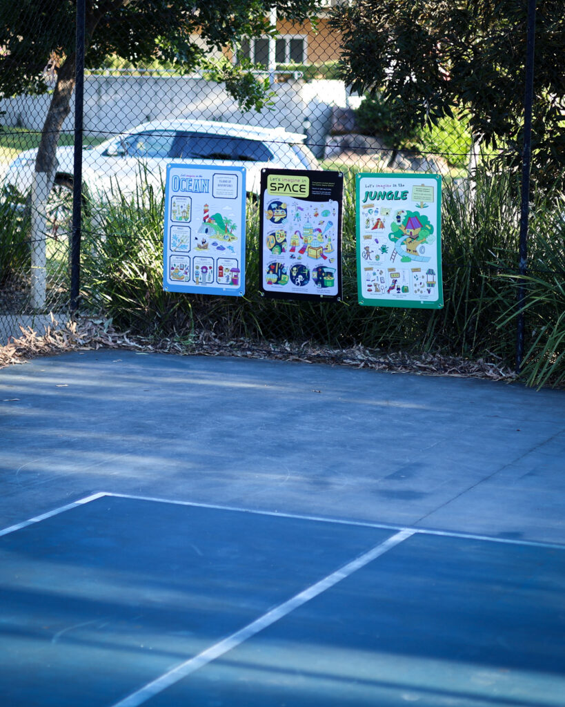 3 Imaginary Play signs on fence by a tennis court