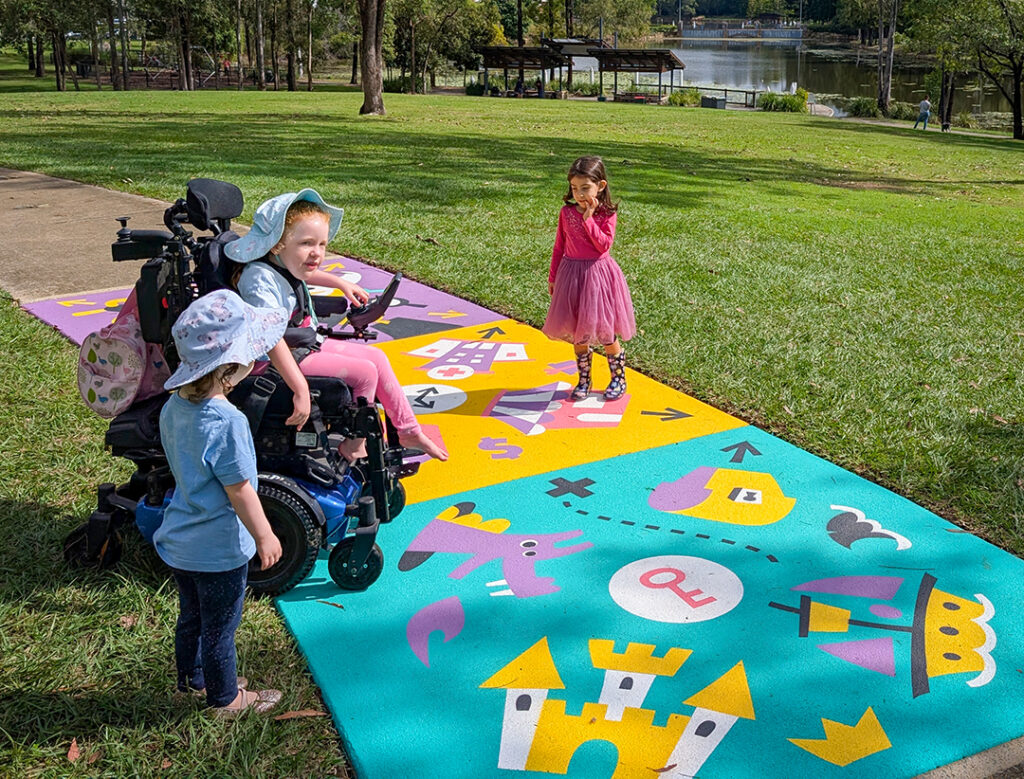 Children playing on a brightly painted path with play prompts